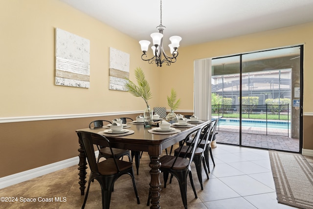 tiled dining room with a notable chandelier