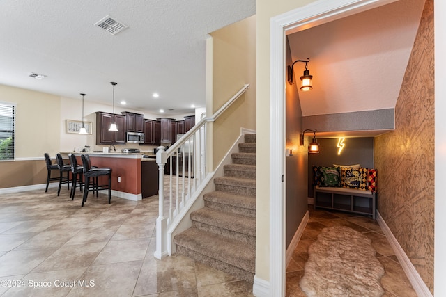 stairway featuring a textured ceiling