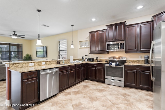 kitchen featuring kitchen peninsula, appliances with stainless steel finishes, dark brown cabinetry, sink, and hanging light fixtures