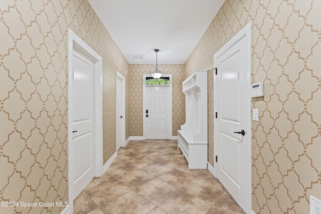 entrance foyer featuring a textured ceiling and light tile patterned flooring