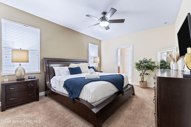 bedroom featuring ceiling fan, ensuite bathroom, and light carpet