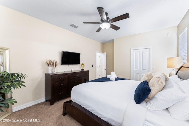 carpeted bedroom featuring ceiling fan and a closet