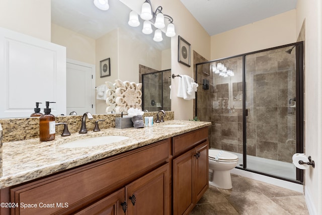 bathroom featuring tile patterned flooring, vanity, toilet, and an enclosed shower