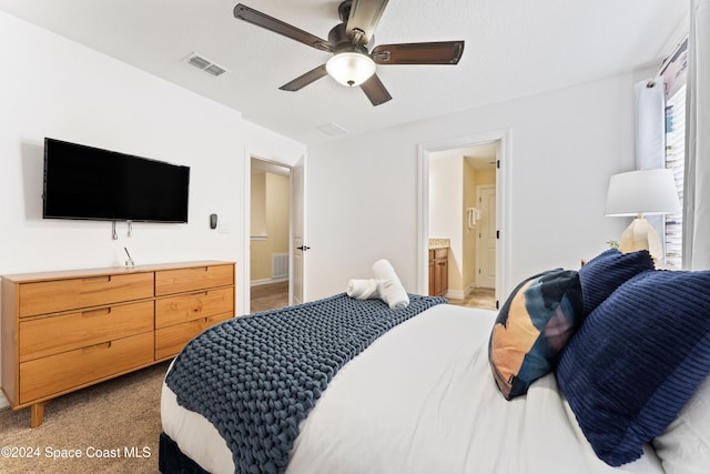 bedroom with ceiling fan, carpet floors, and ensuite bath