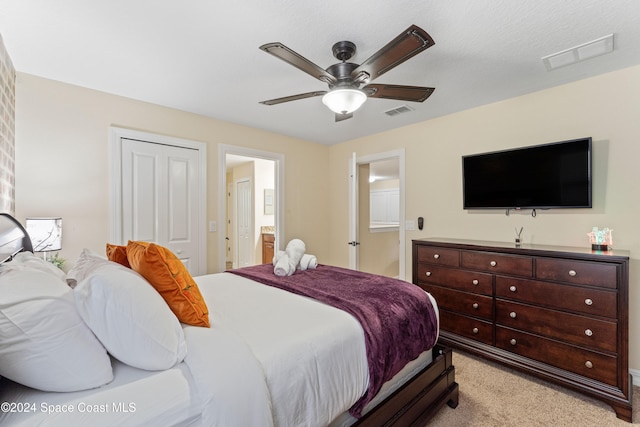 carpeted bedroom with ensuite bath, ceiling fan, and a closet