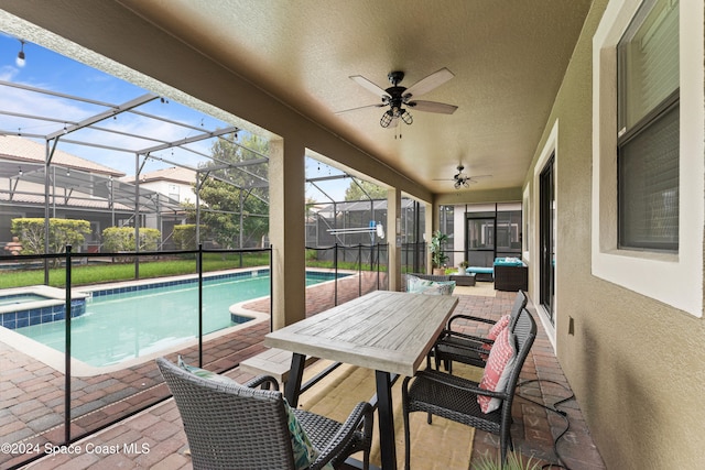 view of swimming pool featuring ceiling fan, a lanai, a patio, and an in ground hot tub