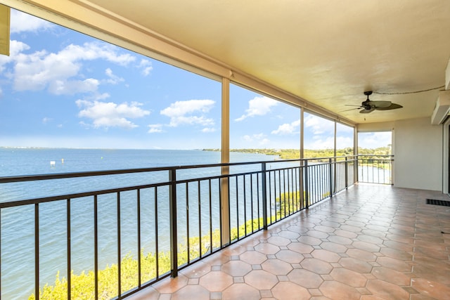 balcony featuring a water view and ceiling fan