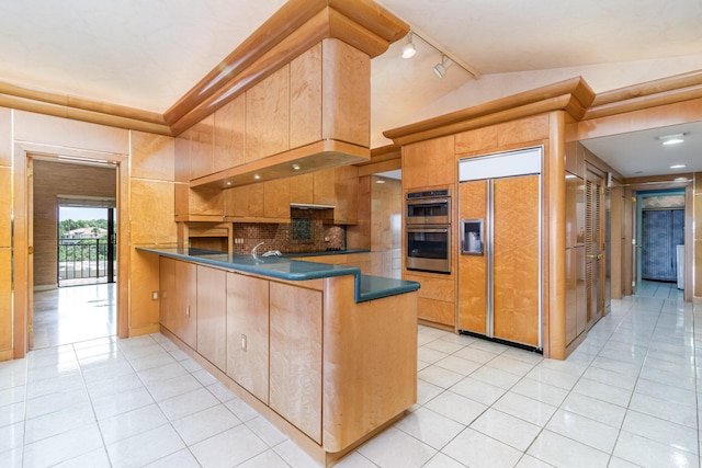 kitchen featuring kitchen peninsula, paneled refrigerator, track lighting, stainless steel double oven, and light tile patterned flooring