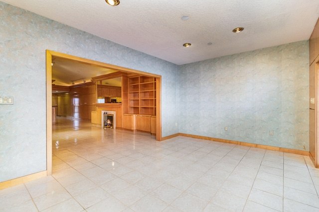 spare room with light tile patterned floors and a textured ceiling