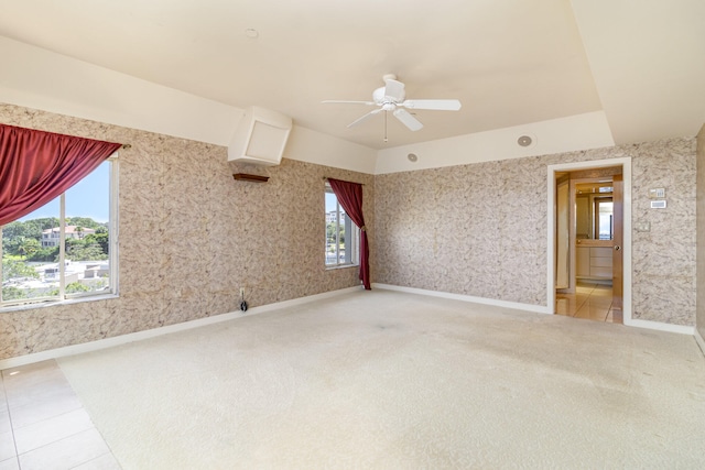 carpeted spare room with plenty of natural light and ceiling fan