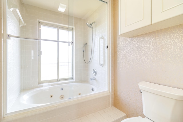 bathroom featuring toilet and tiled shower / bath