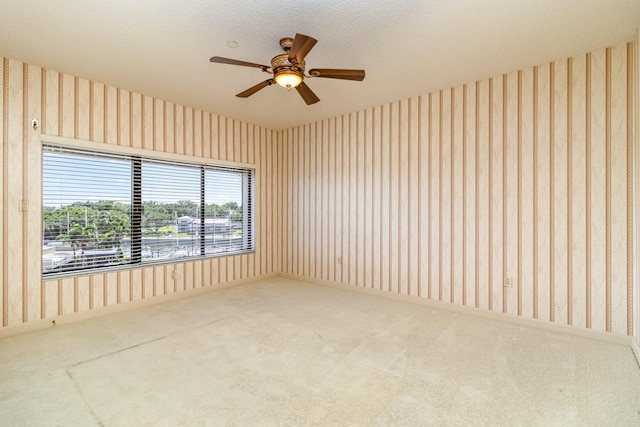 carpeted empty room with a textured ceiling and ceiling fan