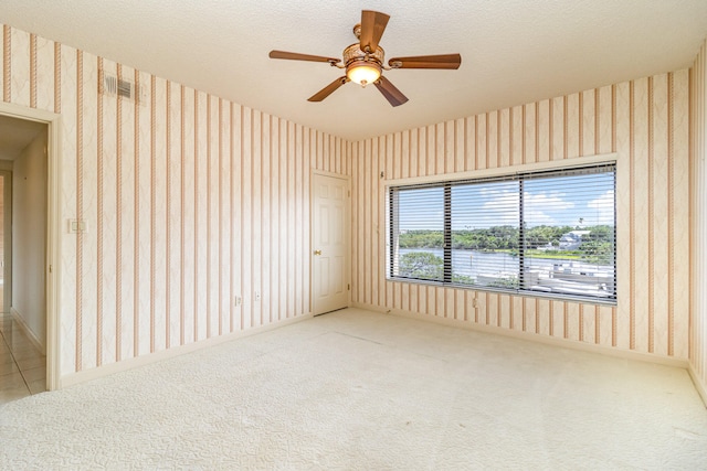 carpeted empty room featuring a textured ceiling and ceiling fan