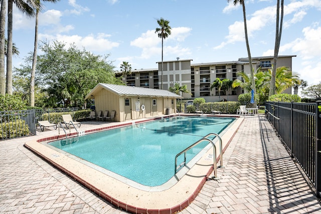 view of swimming pool with an outbuilding and a patio