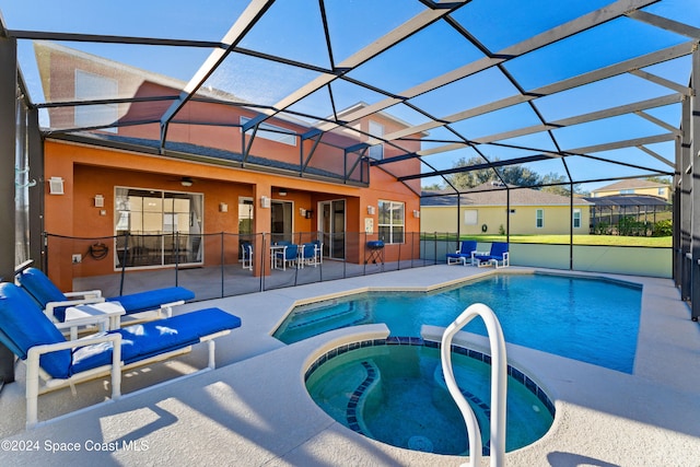 view of swimming pool with ceiling fan, a lanai, an in ground hot tub, and a patio