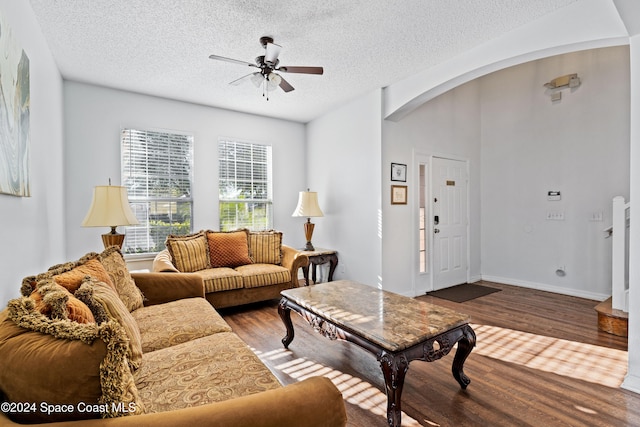 living room featuring ceiling fan, hardwood / wood-style floors, and a textured ceiling