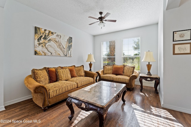 living room with ceiling fan, dark hardwood / wood-style flooring, and a textured ceiling