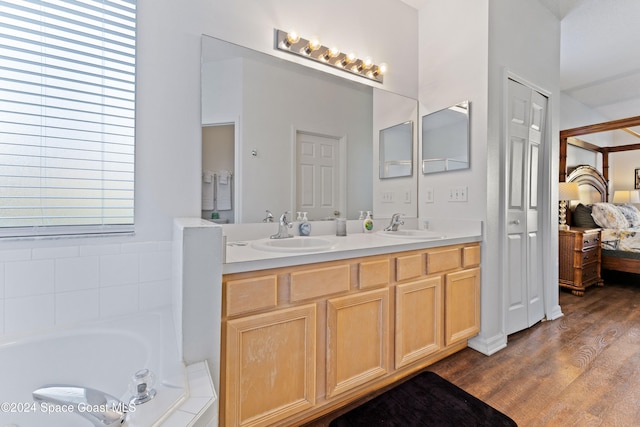 bathroom with vanity, a bath, and hardwood / wood-style flooring