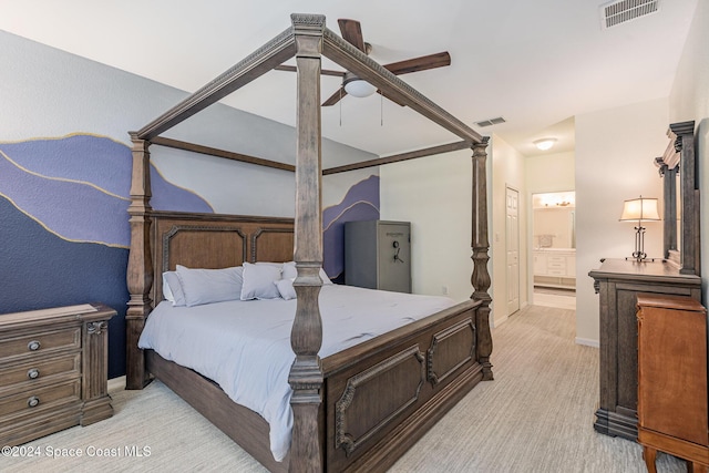 bedroom with light colored carpet, ensuite bath, and ceiling fan