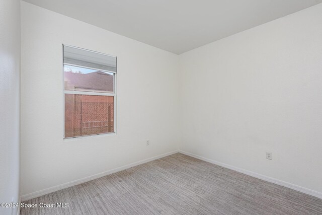 spare room featuring light colored carpet