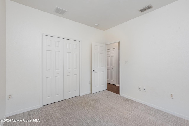 unfurnished bedroom featuring carpet flooring and a closet