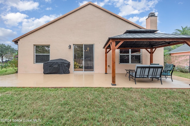 rear view of property with a gazebo, a patio, and a lawn