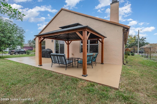 rear view of property with a gazebo, a patio area, a lawn, and an outdoor hangout area