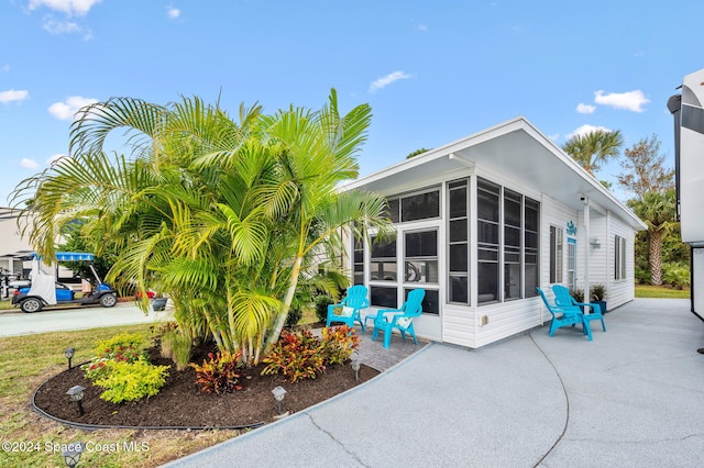 exterior space with a patio and a sunroom