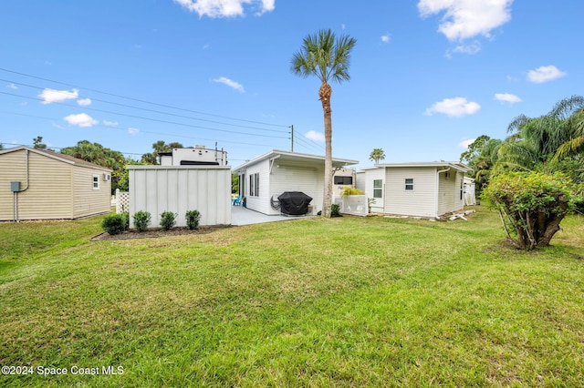 back of property featuring a yard and an outbuilding