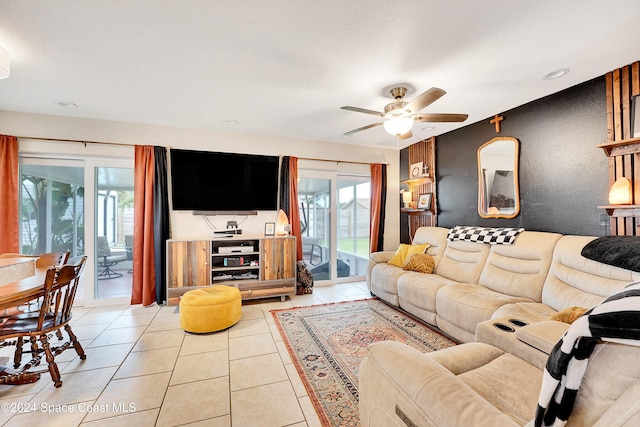 living room with a wealth of natural light, light tile patterned floors, and ceiling fan