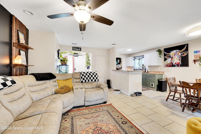 tiled living room with ceiling fan and a textured ceiling