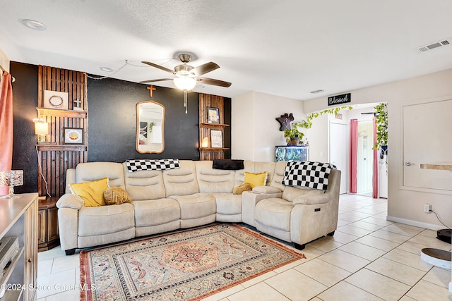 living room featuring ceiling fan, light tile patterned floors, and a textured ceiling