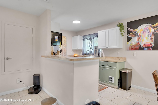 kitchen featuring kitchen peninsula, light tile patterned floors, white cabinetry, and green cabinets