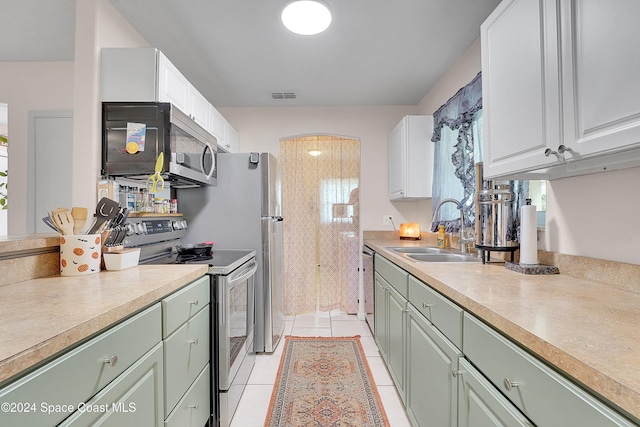 kitchen featuring white cabinets, light tile patterned floors, sink, and appliances with stainless steel finishes