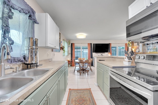 kitchen featuring white cabinets, light tile patterned floors, stainless steel appliances, and sink