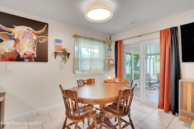 dining area with a textured ceiling and light tile patterned flooring