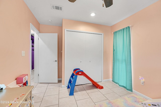 unfurnished bedroom featuring ceiling fan, light tile patterned floors, and a closet