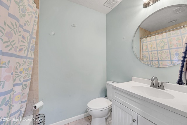 bathroom with vanity, tile patterned flooring, toilet, a textured ceiling, and walk in shower