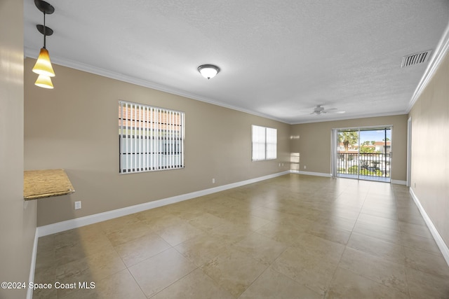 empty room featuring tile patterned floors, ceiling fan, ornamental molding, and a textured ceiling