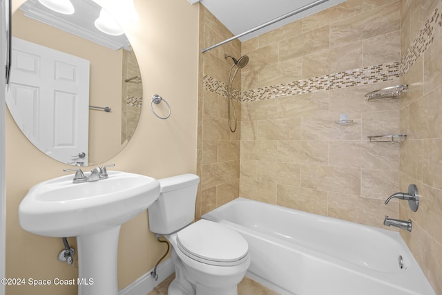 full bathroom featuring crown molding, sink, tiled shower / bath combo, and toilet