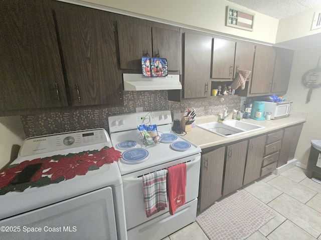 kitchen with white appliances, exhaust hood, sink, light tile patterned floors, and washer / dryer