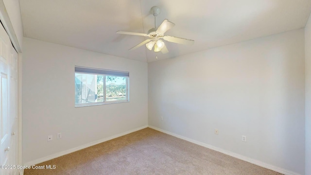 spare room featuring light carpet and ceiling fan