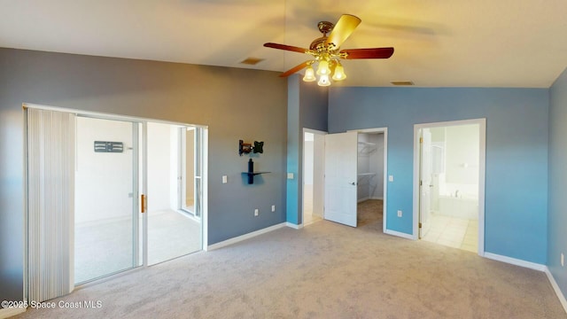 unfurnished bedroom with ensuite bath, ceiling fan, vaulted ceiling, light carpet, and a closet