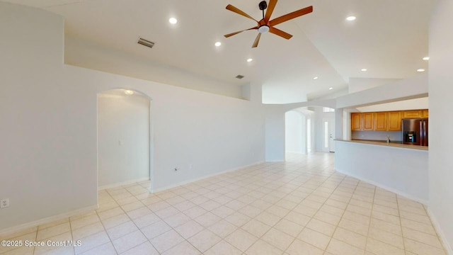 tiled empty room with ceiling fan and lofted ceiling