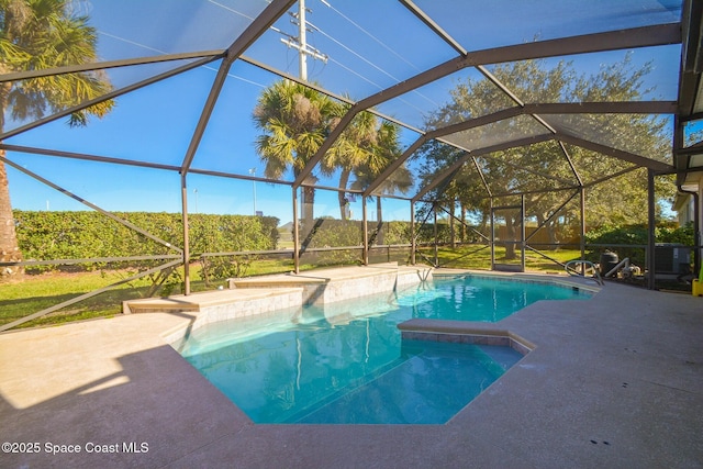 view of pool with glass enclosure and a patio area