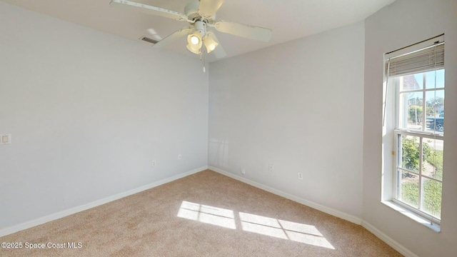 spare room featuring light colored carpet and ceiling fan