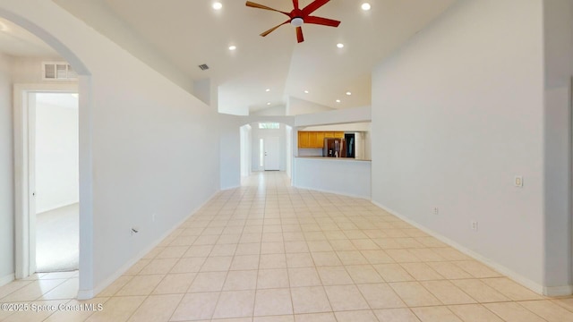 tiled empty room with ceiling fan and vaulted ceiling