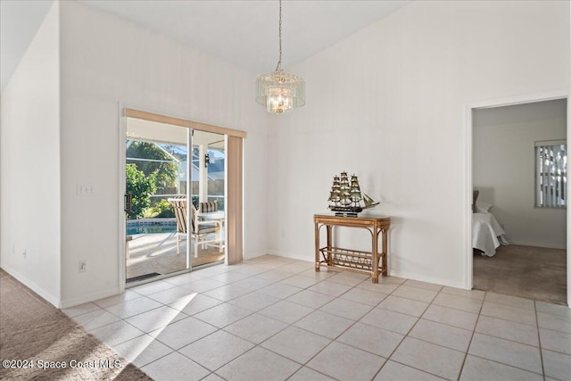 interior space featuring high vaulted ceiling, a notable chandelier, and light tile patterned flooring