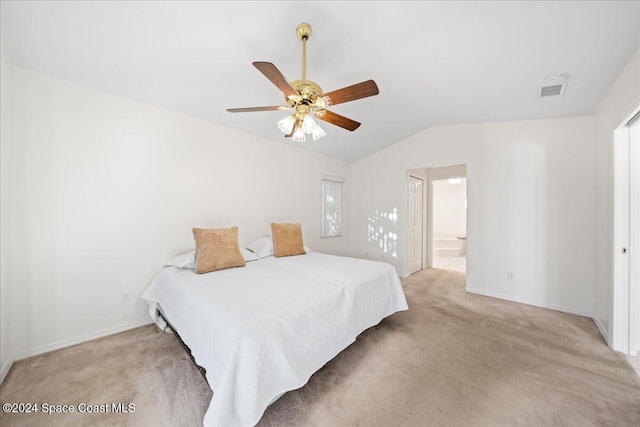 bedroom featuring ceiling fan, lofted ceiling, light carpet, and ensuite bath