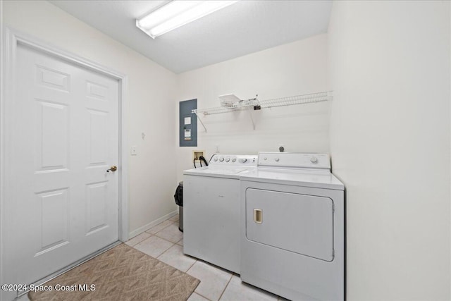 laundry room with light tile patterned floors, independent washer and dryer, and electric panel